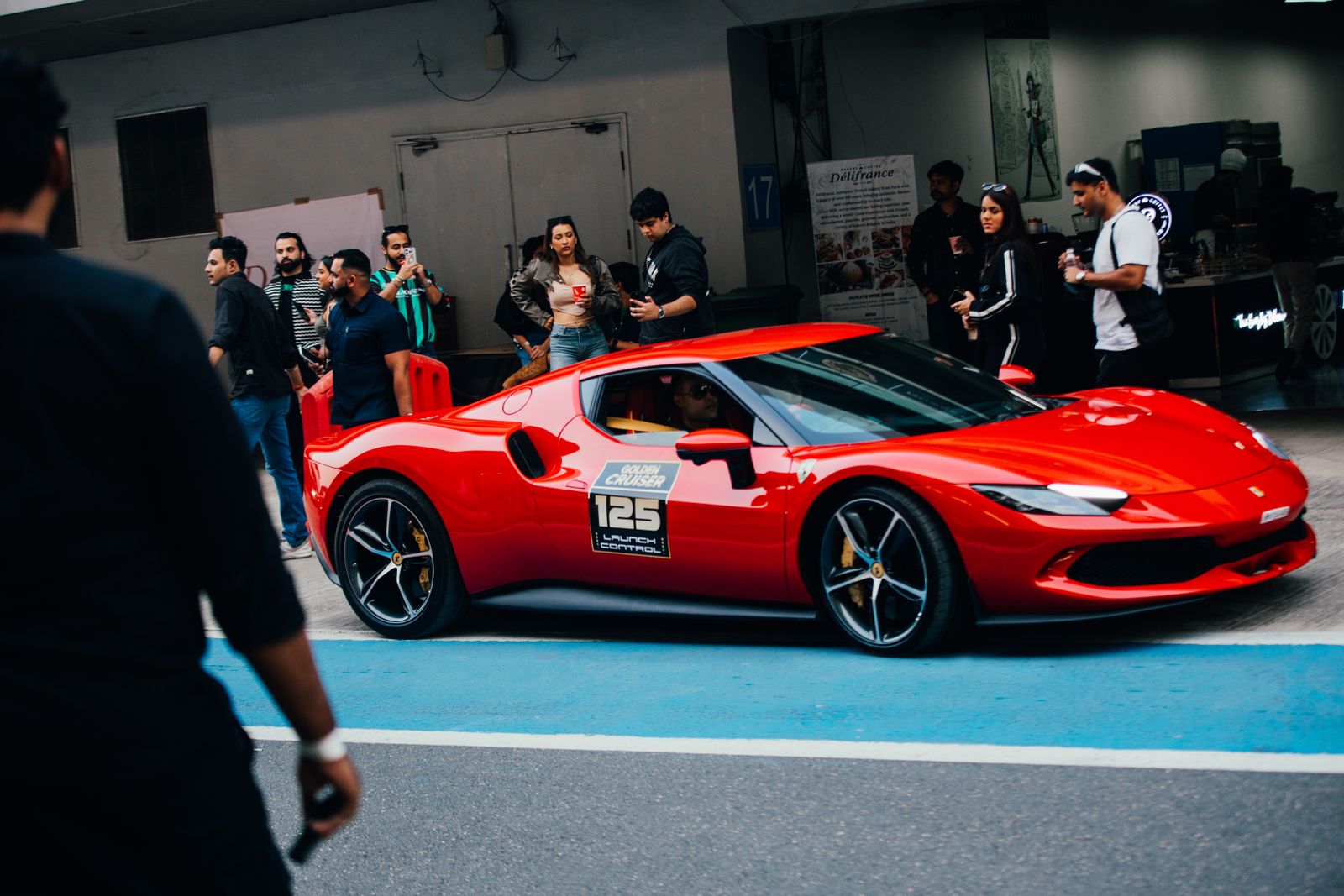 Vibrant red sports car at an automotive event in Greater Noida, India.