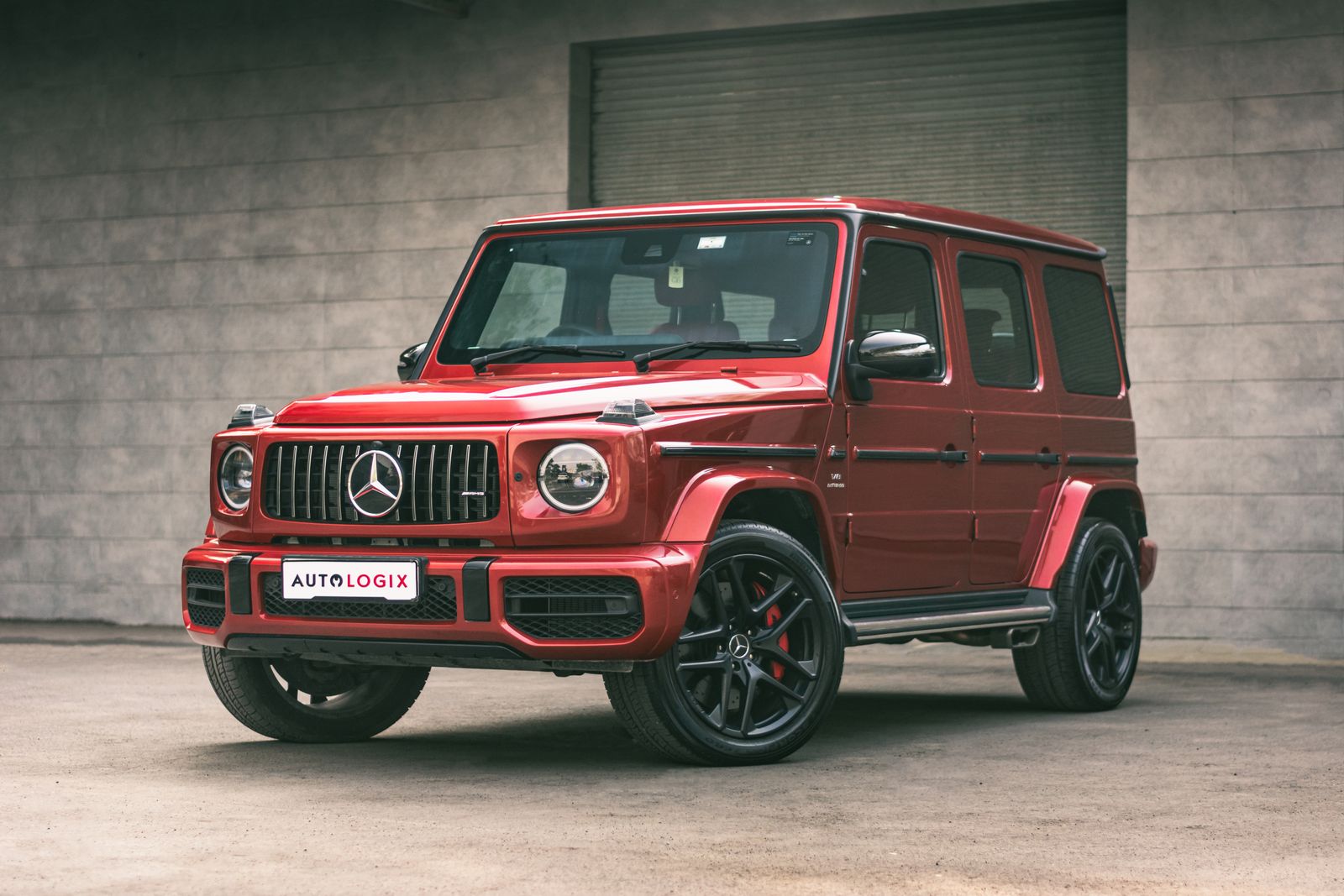 Stylish red Mercedes-Benz G-Class SUV with luxury features and striking design parked outdoors.